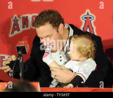 Le voltigeur des Angels de Los Angeles d'introduire, Josh Hamilton lors d'une conférence de presse que sa fille âgée de 15 mois, Stella, est assis sur ses genoux et il mord joyeusement son pied à ESPN Zone à Downtown Disney à Anaheim, Californie le 15 décembre 2012. UPI/Lori Shepler. Banque D'Images