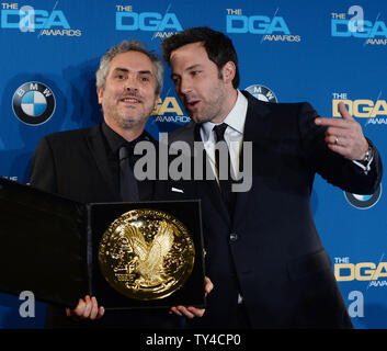 Réalisateur Alfonso Cuaron, apparaît avec son prix backstage après la Directors Guild of America fait son haut honneur de lui pour une réalisation dans un film long métrage de la pesanteur à la 66e Prix annuel de la DGA à Los Angeles le 25 janvier 2014. La célébration de l'instant avec lui est le gagnant de l'an dernier, l'acteur Ben Affleck. UPI/Jim Ruymen Banque D'Images
