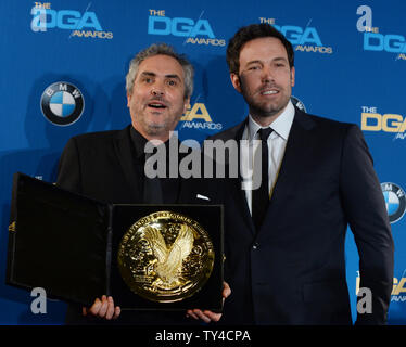Réalisateur Alfonso Cuaron, apparaît avec son prix backstage après la Directors Guild of America fait son haut honneur de lui pour une réalisation dans un film long métrage de la pesanteur à la 66e Prix annuel de la DGA à Los Angeles le 25 janvier 2014. La célébration de l'instant avec lui est le gagnant de l'an dernier, l'acteur Ben Affleck. UPI/Jim Ruymen Banque D'Images