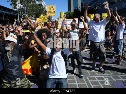 Les gens tiennent leurs mains en scandant "Haut les mains, ne pas tirer sur des" qu'elles défilent dans la petite section de Tokyo de Los Angeles à la suite d'un rassemblement devant le siège de la police le 17 août 2014. Les manifestants se sont réunis pour protester contre la vague d'assassinats d'Afro-Américains non armés par la police dans les villes et villages à travers l'Amérique. Les manifestants ont exigé la justice pour la mort de Ezelll tir Ford à Los Angeles et Mike Brown à Washington la semaine dernière. Ford, un malade mental, 25 ans, homme, et n'était pas armé lorsqu'il a été abattu par la police alors qu'était le brun quand il a été tué avec sa main. UPI/Jim Ruymen Banque D'Images