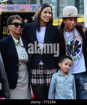 Auteur-compositeur-interprète Pharrell Williams (R) pose avec sa mère Carolyn Williams (L) et son épouse Helen Lasichanh et leur fils de 5 ans au cours de la cérémonie de dévoilement d'une fusée lui rendant hommage à la 2,537ème étoile sur le Hollywood Walk of Fame à Los Angeles le 4 décembre 2014. UPI/Jim Ruymen Banque D'Images