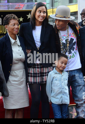Auteur-compositeur-interprète Pharrell Williams (R) pose avec sa mère Carolyn Williams (L) et son épouse Helen Lasichanh et leur fils de 5 ans au cours de la cérémonie de dévoilement d'une fusée lui rendant hommage à la 2,537ème étoile sur le Hollywood Walk of Fame à Los Angeles le 4 décembre 2014. UPI/Jim Ruymen Banque D'Images