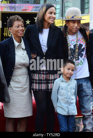Auteur-compositeur-interprète Pharrell Williams (R) pose avec sa mère Carolyn Williams (L) et son épouse Helen Lasichanh et leur fils de 5 ans au cours de la cérémonie de dévoilement d'une fusée lui rendant hommage à la 2,537ème étoile sur le Hollywood Walk of Fame à Los Angeles le 4 décembre 2014. UPI/Jim Ruymen Banque D'Images