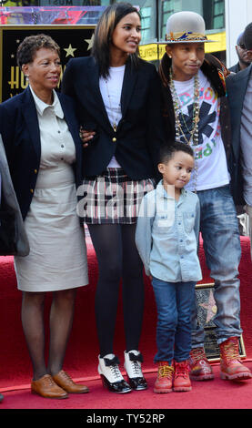 Auteur-compositeur-interprète Pharrell Williams (R) pose avec sa mère Carolyn Williams (L) et son épouse Helen Lasichanh et leur fils de 5 ans au cours de la cérémonie de dévoilement d'une fusée lui rendant hommage à la 2,537ème étoile sur le Hollywood Walk of Fame à Los Angeles le 4 décembre 2014. UPI/Jim Ruymen Banque D'Images
