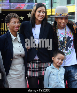Auteur-compositeur-interprète Pharrell Williams (R) pose avec sa mère Carolyn Williams (L) et son épouse Helen Lasichanh et leur fils de 5 ans au cours de la cérémonie de dévoilement d'une fusée lui rendant hommage à la 2,537ème étoile sur le Hollywood Walk of Fame à Los Angeles le 4 décembre 2014. UPI/Jim Ruymen Banque D'Images