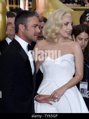 De gauche, l'acteur Taylor Kinney et l'actrice/chanteuse Lady Gaga arrivent sur le tapis rouge pour la 88e Academy Awards, au Hollywood and Highland Center dans la section Hollywood de Los Angeles le 28 février 2016. Photo par Jim Ruymen/UPI Banque D'Images