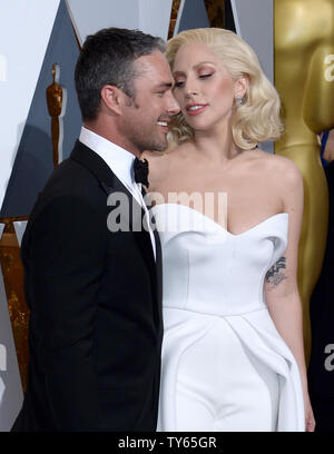 De gauche, l'acteur Taylor Kinney et l'actrice/chanteuse Lady Gaga arrivent sur le tapis rouge pour la 88e Academy Awards, au Hollywood and Highland Center dans la section Hollywood de Los Angeles le 28 février 2016. Photo par Jim Ruymen/UPI Banque D'Images