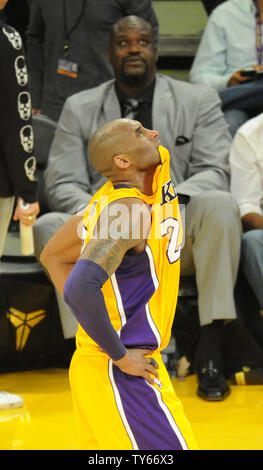 Los Angeles Lakers Kobe Bryant mord son maillot dans son dernier match contre les Utah Jazz au premier semestre au Staples Center de Los Angeles le 13 avril 2016. Shaquille Oneal est assis côté cour. Photo par Lori Shepler/UPI Banque D'Images
