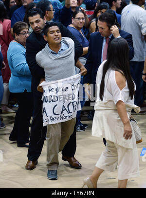 L'un des quelques manifestants est enlevé comme l'ancien secrétaire d'Etat et le candidat démocrate Hillary Clinton aborde partisans pendant un rassemblement à l'Est de Los Angeles College à Los Angeles le 5 mai 2016. Maintenez les protestataires, Hillary Clinton, responsable de l'assassinat du militant des droits des autochtones et de l'environnement Berta Cáceres. Photo par Jim Ruymen/UPI. Banque D'Images