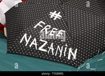 Londres, Royaume-Uni. 25 Juin, 2019. Un parapluie avec le hashtag vu FreeNazanin en face de l'ambassade d'Iran à l'appui de Nazanin Zaghari-Ratcliffe. Mari de Iranian-British Zaghari-Ratcliffe national Nazanin, Richard Ratcliffe, actuellement sur le 11e jour de grève de la faim à l'extérieur de l'ambassade d'Iran à Londres. Il agit en solidarité avec sa femme, qui est également refuser de manger pour protester contre son emprisonnement injuste en Iran pour espionnage frais. Credit : SOPA/Alamy Images Limited Live News Banque D'Images