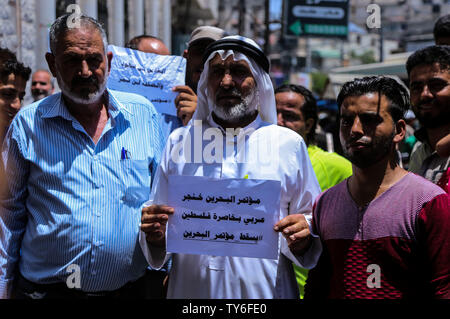 Gaza, la Palestine. 25 Juin, 2019. Un manifestant palestinien est titulaire d'un placard pendant la protestation contre Bahreïn atelier POUR NOUS JOINDRE plan de paix dans la bande de Gaza. Credit : SOPA/Alamy Images Limited Live News Banque D'Images