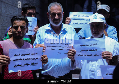 Gaza, la Palestine. 25 Juin, 2019. Des manifestants palestiniens tiennent des pancartes pendant la protestation contre Bahreïn atelier POUR NOUS JOINDRE plan de paix dans la bande de Gaza. Credit : SOPA/Alamy Images Limited Live News Banque D'Images