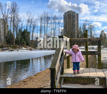 Bébé de 20 mois profitant du beau temps à l'extérieur. Bébé fille portraits en lumière naturelle. Petite fille close up photos dans la nature, en hiver Banque D'Images