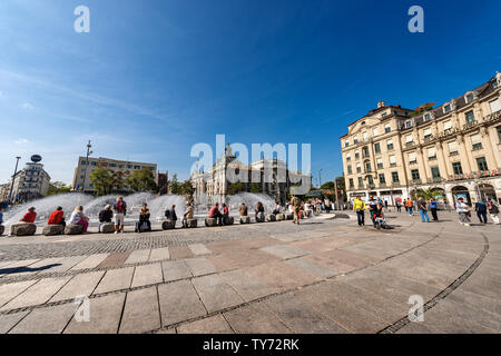 Les touristes visitent la Karlsplatz ou Stachus, grande place, dans le centre de Munich avec une fontaine, en arrière-plan le Palais de Justice (Justizpalast), Allemagne Banque D'Images