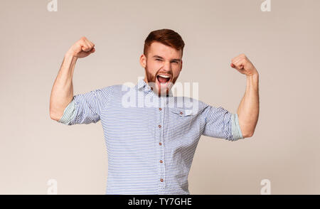 Jeune homme montrant son pouvoir dans les biceps sur camera Banque D'Images