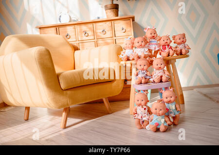 Groupe de cute baby dolls sur la table sur fond lumineux Banque D'Images