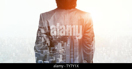 Double Exposure of businessman standing back with cityscape Banque D'Images