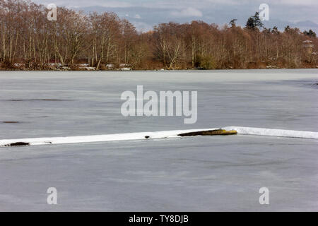 belle scène d'hiver avec lac gelé, couvert de glace brisante. arbres en arrière-plan. Nuageux, ciel bleu. Superbe paysage d'hiver. Un ton frais Banque D'Images