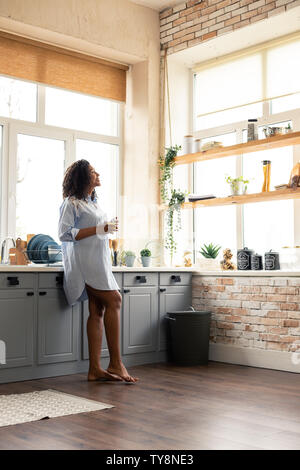 Femme enceinte debout avec un verre d'eau. Banque D'Images