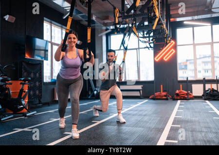 L'excès de femme un sentiment positif tout en exerçant avec TRX Banque D'Images