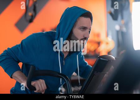 L'homme athlétique brune réfléchie alors que le cyclisme en sentiment de sport Banque D'Images