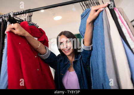 Close-up portrait of dark-haired femme vêtements poussant dans le showroom Banque D'Images