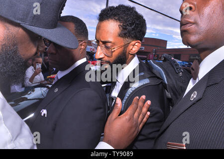 Nipsey Hussle, le frère de Samiel Asghedom est réconforté par un ventilateur car il marche dans le cortège funèbre qui suit son frère's memorial au Staples Center de Los Angeles le 11 avril 2019. L'artiste en nomination a été tué la semaine dernière devant le magasin de vêtements de marathon qu'il a fondée en 2017. Photo par Jim Ruymen/UPI Banque D'Images