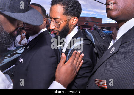 Nipsey Hussle, le frère de Samiel Asghedom est réconforté par un ventilateur car il marche dans le cortège funèbre qui suit son frère's memorial au Staples Center de Los Angeles le 11 avril 2019. L'artiste en nomination a été tué la semaine dernière devant le magasin de vêtements de marathon qu'il a fondée en 2017. Photo par Jim Ruymen/UPI Banque D'Images