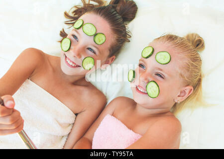 Belles filles avec masque facial de concombre. Enfants prises de photos de son auto. Banque D'Images