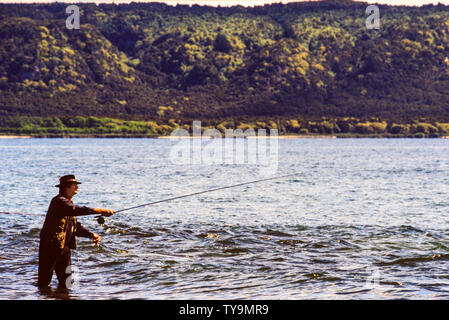 Nouvelle Zélande, île du Nord. Man fishing in Lake Taupo, un relevé des stocks de pêche de la truite et de la truite brune introduit. Photo : © Simon Grosset. Banque D'Images