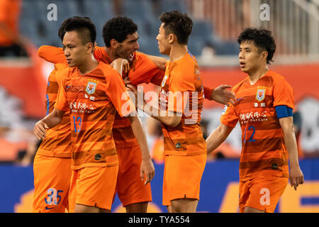 Les joueurs de la Chine Shandong Luneng Taishan C.F. célébrer après avoir marqué contre la Chine Guangzhou Evergrande Taobao C.F. dans le huitième de finale lors de la Ligue des Champions de l'AFC 2019 à Jinan City, Shandong province de Chine orientale, le 25 juin 2019. Guangzhou Evergrande avancé pour les quarts de finale après avoir battu l'ACL Shandong Luneng 6-5 dans une palpitante penalty shoot-out mardi. Banque D'Images