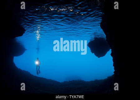 Diver (MR) à l'entrée d'une caverne à l'extérieur de l'île de Gato, Bohol Sea, Philippines, Asie du sud-est. Banque D'Images