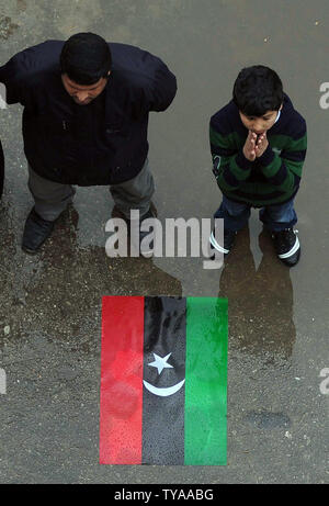 Les protestataires se tenir en face de l'ancien drapeau national qu'ils crier des slogans contre le leader libyen Mouammar Kadhafi près du port de Benghazi, en Libye le long de la côte méditerranéenne, le 6 mars 2011. Loyal et les forces rebelles continuent à se battre pour le contrôle du pays. UPI/Mohamaad Hosam Banque D'Images