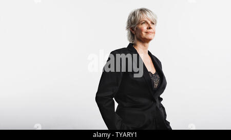 Portrait of senior femme entrepreneur à la route. Femme en armoiries officielles du standing against white background. Banque D'Images
