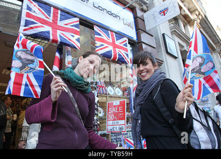 Les touristes lever des drapeaux à l'effigie de Son Altesse Royale le prince William et Kate Middleton près de Trafalgar Square avant le mariage royal, à Londres, le 27 avril 2011. Un grand nombre de spectateurs sont attendus pour se réunir à la place de regarder une émission du mariage, qui aura lieu le 29 avril 2011. UPI/ David Silpa Banque D'Images