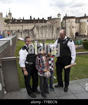 Les agents de police de Londres mis leurs casques sur les jeunes touristes en face de la Tour de Londres le 21 juillet 2012. Les derniers préparatifs sont faits avec des cérémonies d'ouverture des Jeux de 2012 six jours. UPI/Terry Schmitt Banque D'Images