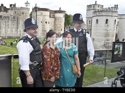 Les femmes indiennes posent pour une photo avec les agents de police de Londres en face de la Tour de Londres le 21 juillet 2012. Les derniers préparatifs sont faits avec des cérémonies d'ouverture des Jeux de 2012 six jours. UPI/Terry Schmitt Banque D'Images