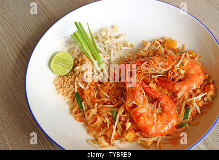 Style thaï nouilles frites ou Pad thaï aux crevettes parées servi sur table en bois Banque D'Images