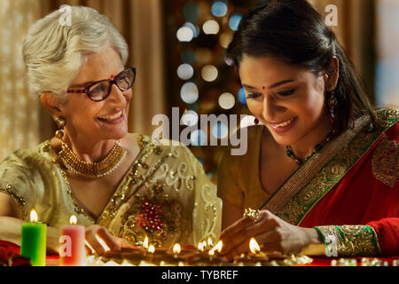 Fille, décorer la maison avec belle-mère à l'occasion de Diwali Banque D'Images