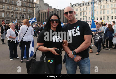 Un couple soutenant la campagne Yes pose devant l'appareil photo sur la journée des résidents écossais décide de l'avenir l'orientation politique de leurs pays prendra à Glasgow, Ecosse, le 18 septembre 2014.'Quatre-vingt-dix-sept pour cent de la population a des inscrits pour voter.Le verdict sera annoncé demain matin. UPI/Hugo Philpott Banque D'Images