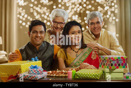 Family et souriant avec des cadeaux à l'occasion de Diwali Banque D'Images