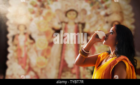 'Portrait d'une belle mariée Bengali woman blowing , pendant les célébrations de Durga puja conque à Durga puja ' Banque D'Images