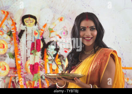 Portrait d'une belle mariée Bengali woman holding Puja, Thali au cours de Durga puja célébrations Banque D'Images