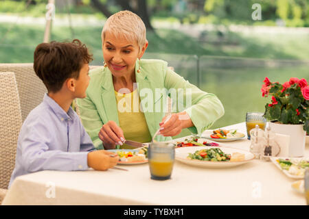 Aimer belle grand-mère son petit-fils donnant certains salad Banque D'Images