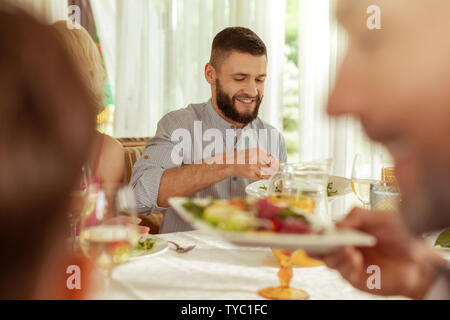 Beau brun en train de déjeuner avec les parents Banque D'Images