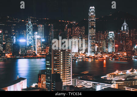 La ville de Hong Kong skyline at night, tourné à partir de Kowloon. Montrant des gratte-ciel dans un ton de couleur dynamique entourant le célèbre port de Victoria. Banque D'Images