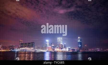 Hong Kong ville avec port de Victoria la nuit, tiré de l'île de HK, avec un ciel coloré montrant les lumières des gratte-ciels de la pollution. Banque D'Images