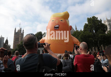 Un bébé de six mètres de Donald Trump dirigeable survole la place du Parlement dans le centre de Londres que de manifestants contre le président américain Donald Trump's visite de trois jours en Grande-Bretagne le 13 juillet 2018. Photo par Hugo Philpott/UPI Banque D'Images