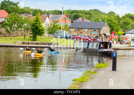 Trois kayakistes quitte le bassin de Trevor sur le canal de Llangollen et partir à travers l'aqueduc de Pontcysyllte haut au-dessus de la rivière Dee, Clwyd, Pays de Galles, Royaume-Uni Banque D'Images