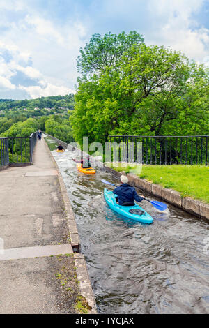 Trois kayakistes quitte le bassin de Trevor sur le canal de Llangollen et partir à travers l'aqueduc de Pontcysyllte haut au-dessus de la rivière Dee, Clwyd, Pays de Galles, Royaume-Uni Banque D'Images